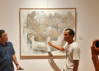 I Wayan Sadu (tengah) saat menjelaskan salah satu karyanya kepada pengunjung, didampingi kurator, Wayan Seriyoga Parta (kiri)