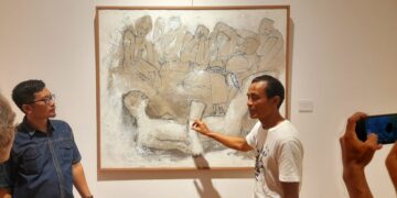 I Wayan Sadu (tengah) saat menjelaskan salah satu karyanya kepada pengunjung, didampingi kurator, Wayan Seriyoga Parta (kiri)