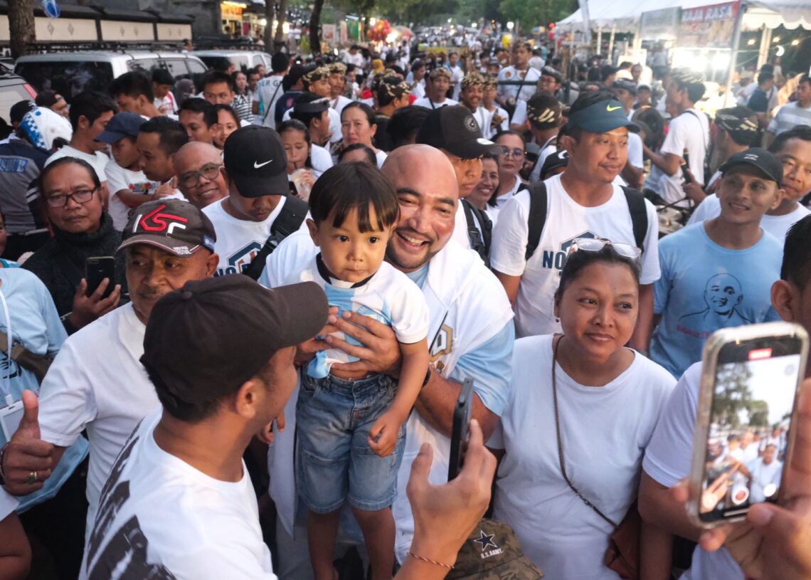 De Gadjah menggendong seorang anak saat Jalan Sehat Relawan De Gadjah di Buleleng.
