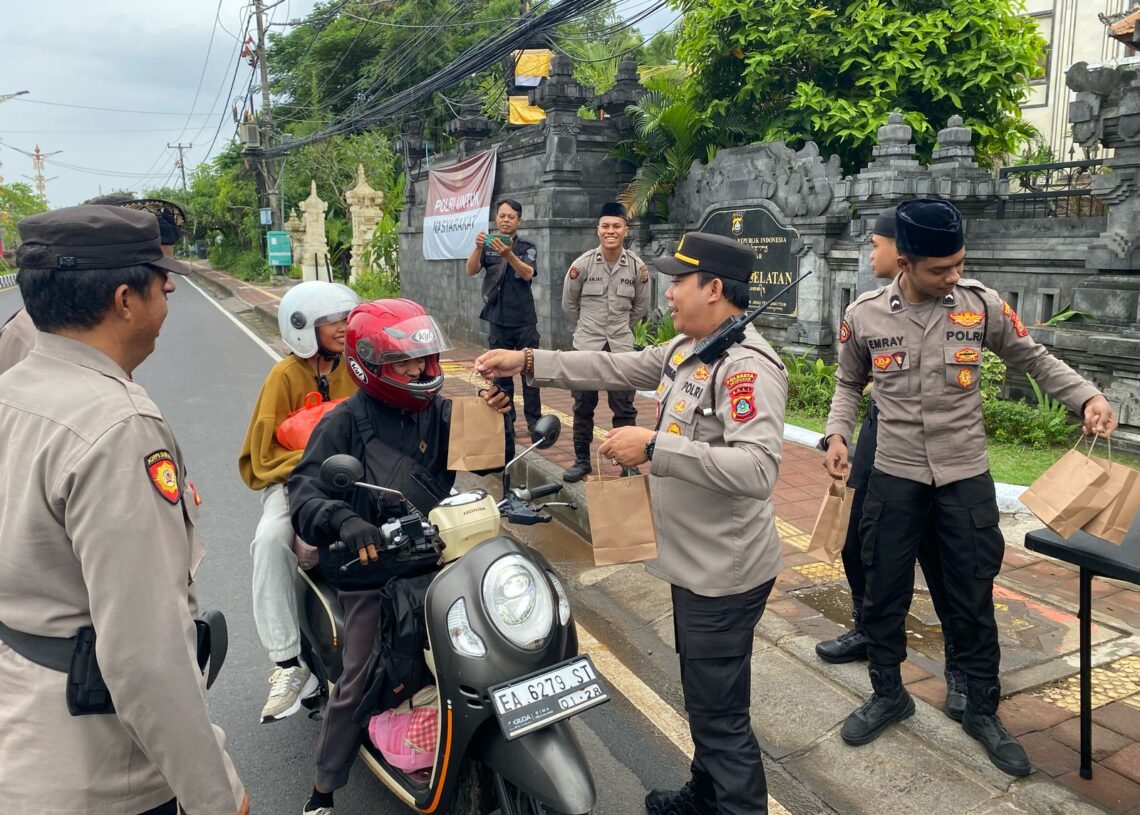 Kapolsek Kuta Selatan, AKP I Komang Agus Dharmayana, S.I.K., M.Si., saat membagikan takjil kepada warga. -Balitopik.com