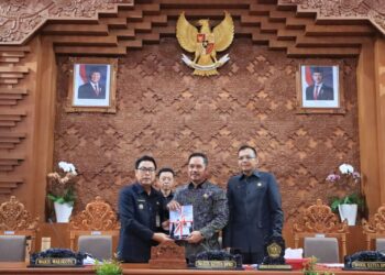 Wakil Wali Kota Denpasar I Kadek Agus Arya Wibawa (kiri) dan Wakil Ketua DPRD Denpasar Made Oka Cahyadi Wiguna memegang LKPJ Tahun 2024. -Balitopik.com