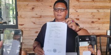 Gede Angastia saat menunjuk berkas laporannya terhadap Demer. -Balitopik.com