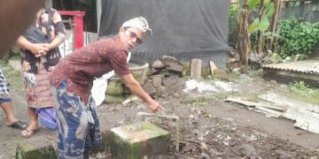 Ketut Sepot saat menunjuk tangki tertutup penampung kotoran babi yang dijadikan biogas. -Balitopik.com