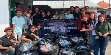Anggota PMKRI Cabang Denpasar saat menyerahkan botol plastik bekas kepada pemulung. -Balitopik.com