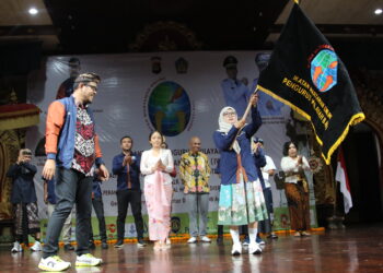 Pengibaran pataka oleh Ketua IWO Bali Tri Widiyanti. -Balitopik.com