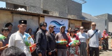 Yayasan Sungai Kasih saat menyalurkan bantuan beras dan biskuit untuk warga Denpasar yang terdampak banjir. -Balitopik.com