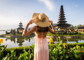 Seorang turis saat berpose di Danau Bratan Bedugul, salah satu ikon pariwisata Bali. -IST/Balitoik.com