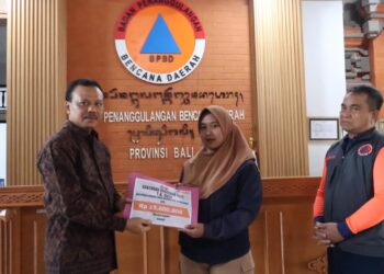 Sekda Bali Dewa Made Indra saat menyerahkan santunan kepada korban banjir. -IST/Balitopik.com