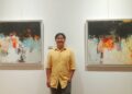 Pelukis abstrak asal Bali, Tien Hong berpose diantara dua karyanya. -Balitopik.com