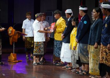 Gubernur Bali, Wayan Koster saat menyerahkan bantuan Program Satu Keluarga Satu Sarjana secara simbolis. -Balitopik.com