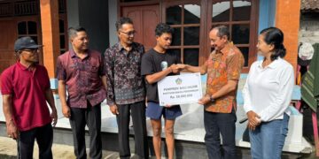 Staf Ahli Gubernur Bali Bidang Permukiman dan Sarana Prasarana Wilayah, Tjok Bagus Pemayun saat menyerahkan bantuan. -Balitopik.com