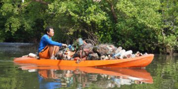 Potret seorang warga sedang mengangkut sampah plastik dari kawasan Mangrove Batu Lumbang, Denpasar. -BALITOPIK.COM
