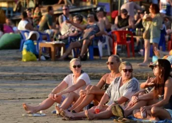 Sejumlah turis sedang bersantai di salah satu pantai di Bali. -IST/BALITOPIK.COM