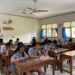 Siswa SMK PGRI 2 Denpasar mengerjakan tes bahasa Inggris HeadWay melalui handphone di dalam kelas.