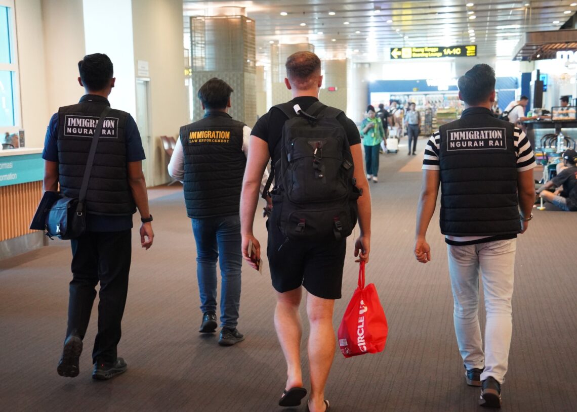 Petugas Imigarsi Ngurah Rai saat mengawal pendeportasian terhadap GI. -BALITOPIK.COM