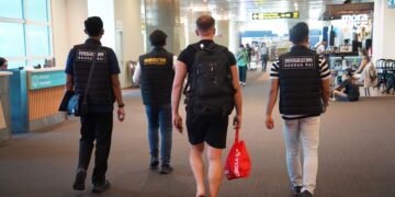 Petugas Imigarsi Ngurah Rai saat mengawal pendeportasian terhadap GI. -BALITOPIK.COM