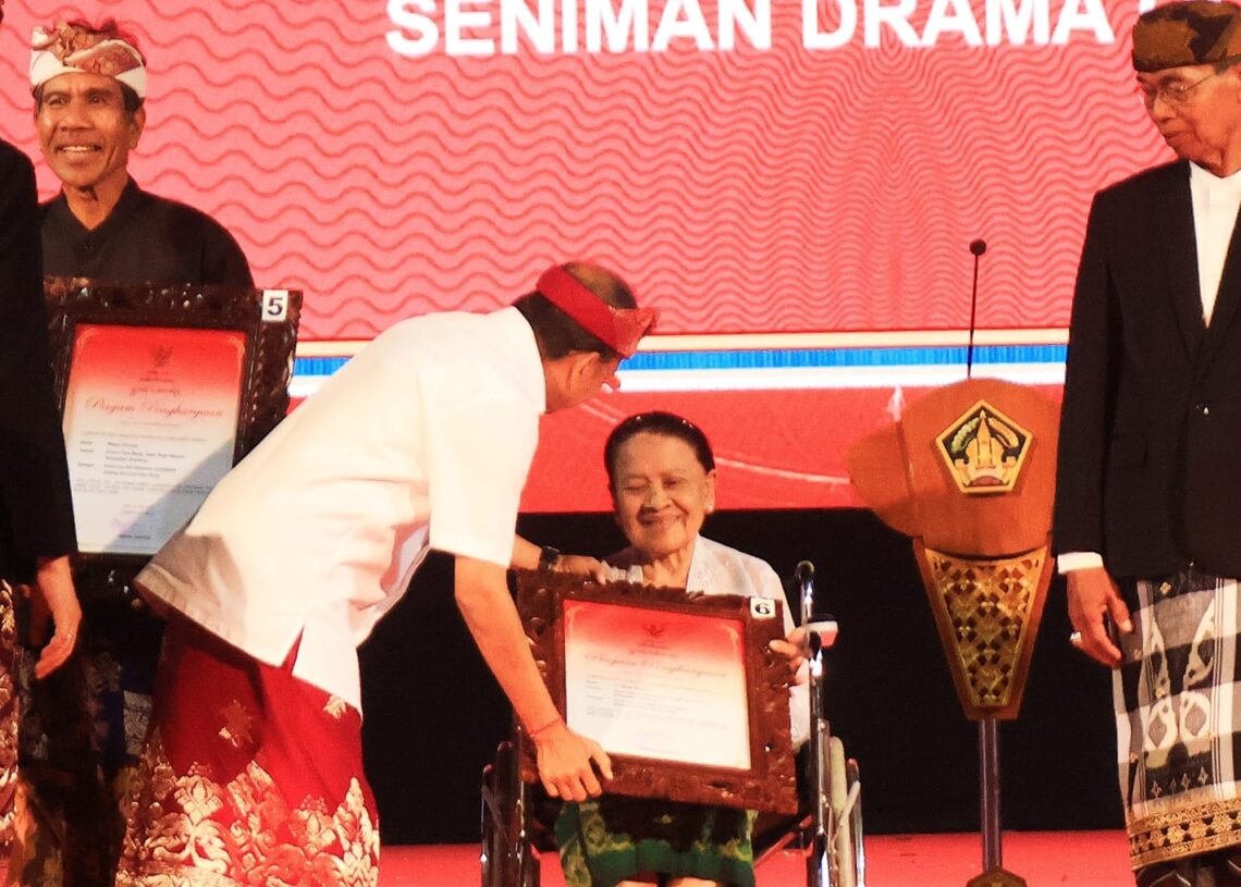 Gubernur Wayan Koster saat memberikan penghargaan kepada salah satu penerima Adi Sewaka Nugraha. -IST