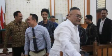 Penggugat empat media Togar Situmorang (baju putih) disusul tim kuasa hukum empat media yang tergabung SJB keluar ruang sidang usai mediasi tidak menemui titik temu di PN Denpasar, Selasa (4/8?2026). -IST