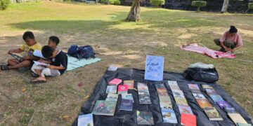 Potret sejumlah anak-anak membaca buku yang dipajang oleh AJI Denpasar di lapangan Renon. -IST