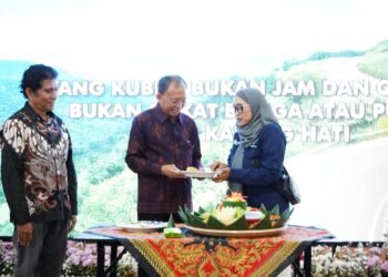 Gubernur Bali Wayan Koster dan Ketua Ikatan Wartawan Online (IWO) Bali Tri Widiyanti saat memotong tumpeng. -IST