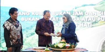 Gubernur Bali Wayan Koster dan Ketua Ikatan Wartawan Online (IWO) Bali Tri Widiyanti saat memotong tumpeng. -IST