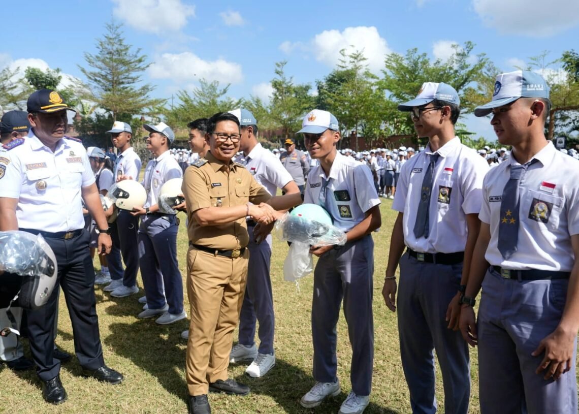 Bupati Badung I Wayan Adi Arnawa saat menyerahkan helm kepada salah satu pelajar sebagai simbol tertib lalu lintas. -IST