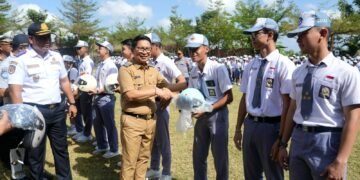 Bupati Badung I Wayan Adi Arnawa saat menyerahkan helm kepada salah satu pelajar sebagai simbol tertib lalu lintas. -IST