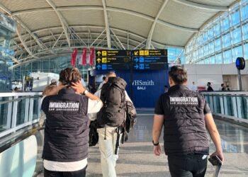 Petugas Imigrasi Ngurah Rai saat mengawal pendeportasian terhadap 12 WNA. -IST
