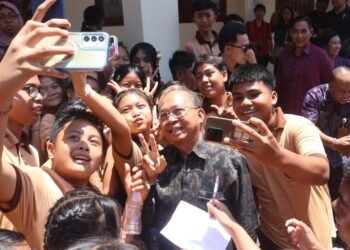 Gubernur Bali Wayan Koster saat diajak swafoto oleh sejumlah murid SMPN 13 Denpasar. -BALITOPIK.COM